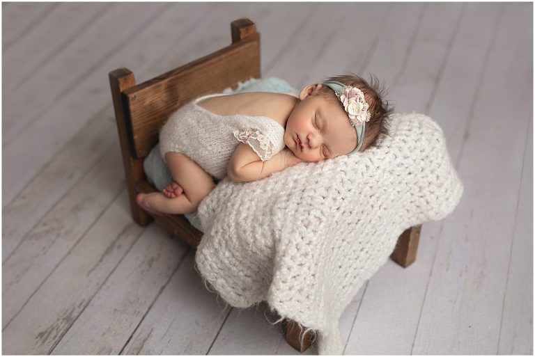 newborn photo, soft sweet cream and blue with a blue tieback.