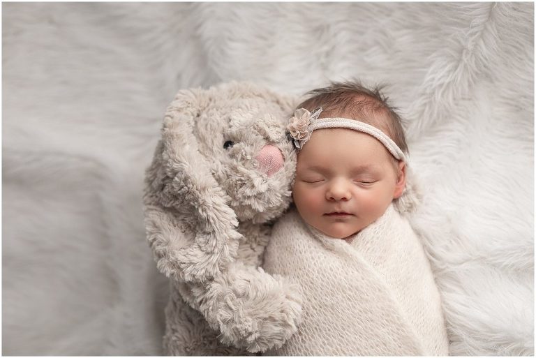 Newborn photography with bunny stuffed animal.